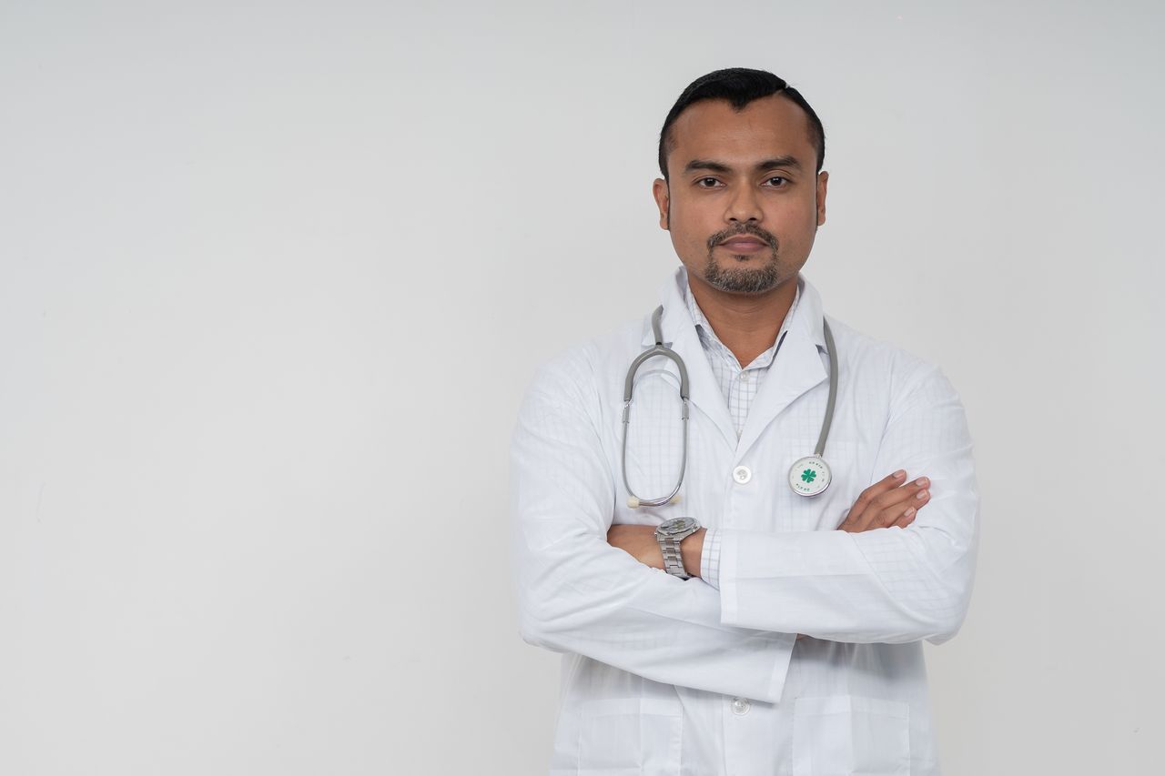 Offerings Confident South Asian male doctor in white coat with stethoscope, portrait shot.