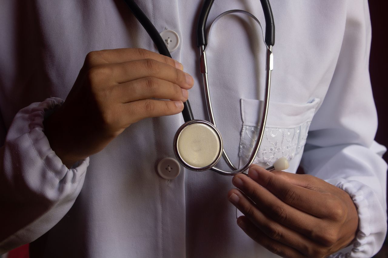 Offerings A close-up image of a doctor in a white lab coat holding a stethoscope, symbolizing healthcare.